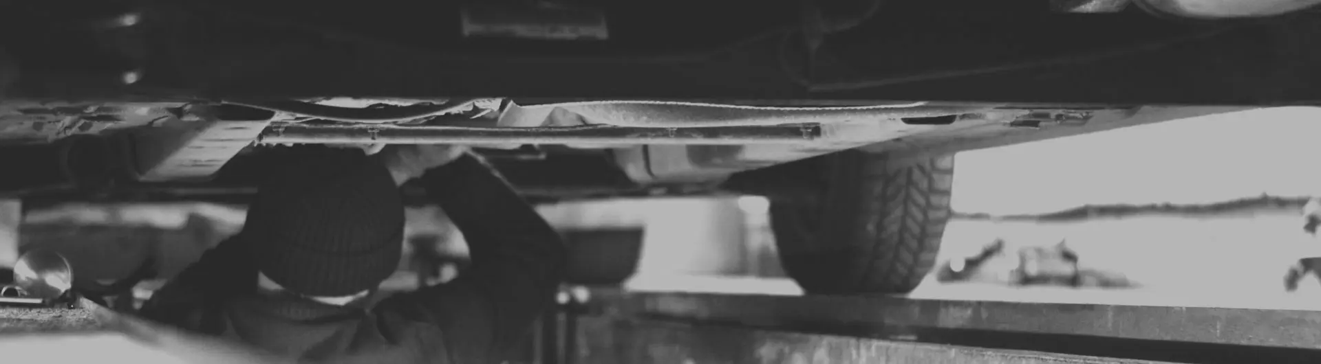 A KP Serwis mechanic working underneath a raised car