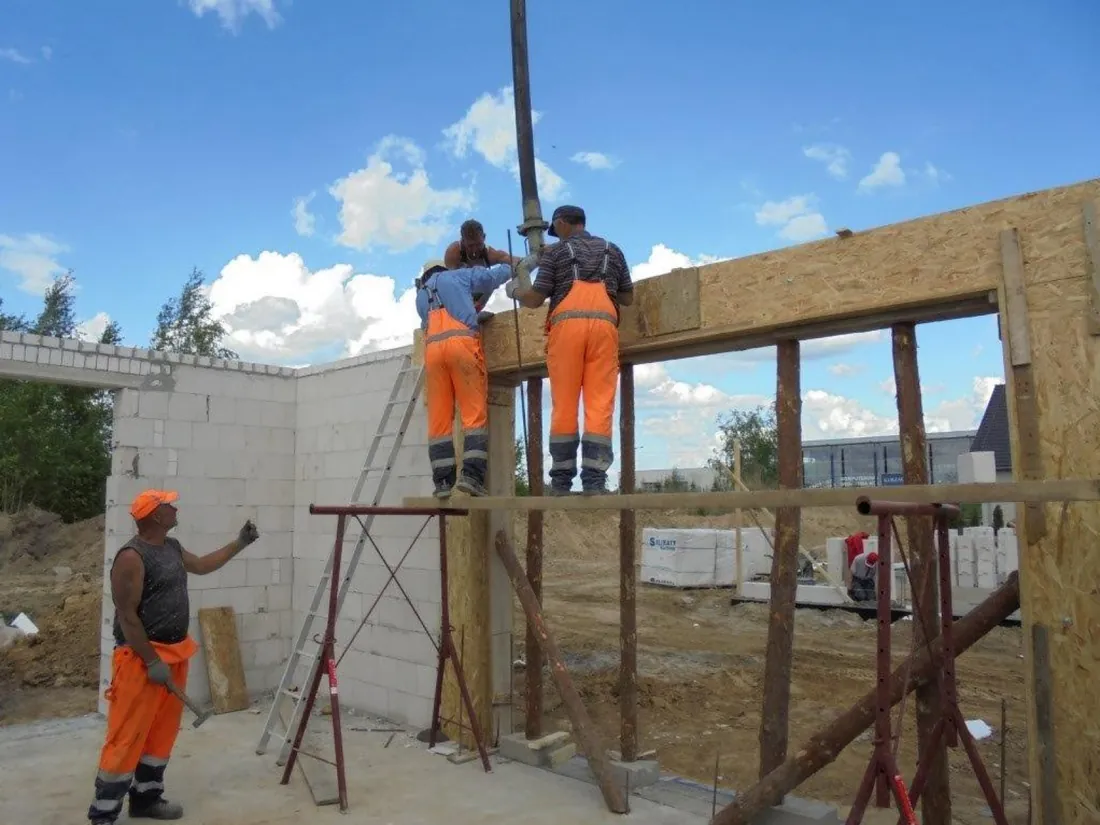 Operatives on scaffolding pouring columns and beams