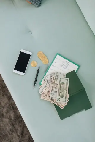 Banknotes, a phone and a notebook on a table