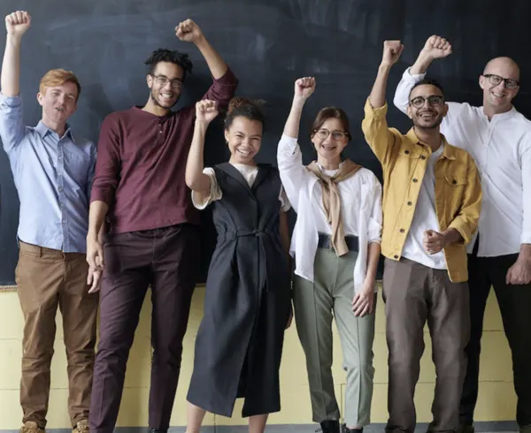 A cheerful group of young people with their arms raised