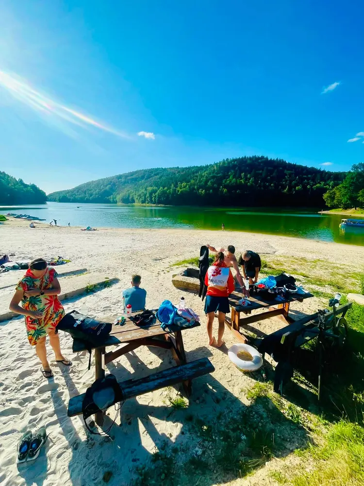 Trinergy athletes relaxing by a lake during the camp in the Izera Mountains
