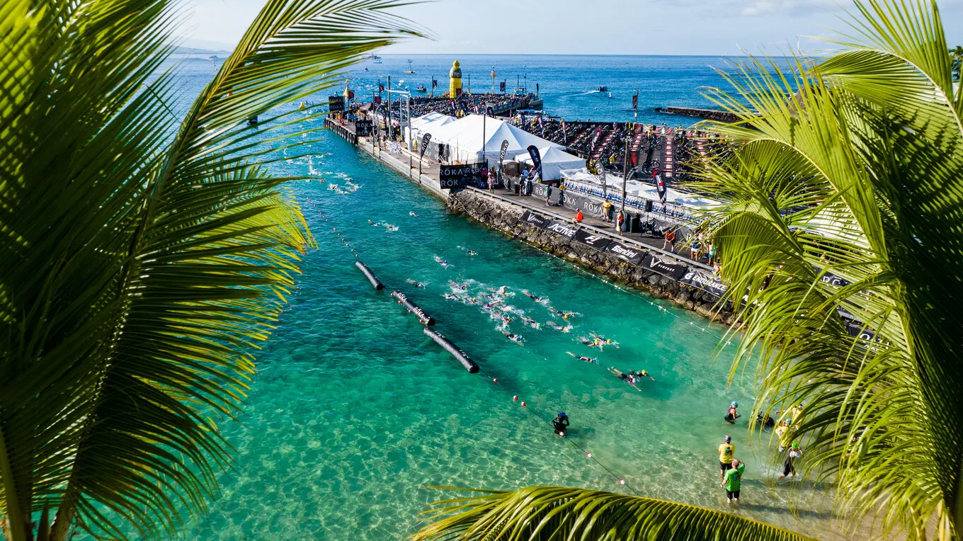 The swim at the Ironman World Championship in Hawaii, seen through palm leaves